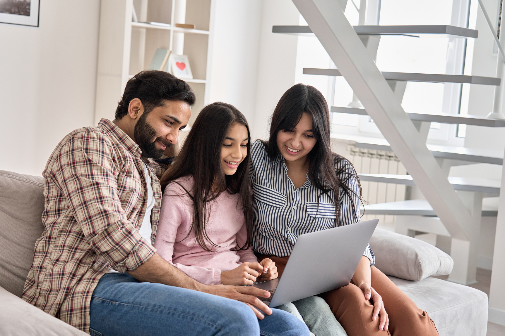 Family Couple with Teen Daughter Using Laptop at Home